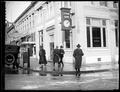 People on sidewalk in front of Citizen's Bank, Grand Ave, Portland. Clock on building.