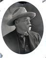 Portraits of a man in a suit and hat with cigar in mouth