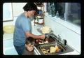 Child with person churning butter, Oregon, circa 1971