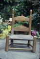 Small rawhide chair, seat is tanned, not woven, once a rocker, then rocker cut off, top finials are worn slanted because the kids in the family learned to walk by turning the chair upside down and pushing it, 20 x 10 x 10 inches, 1870