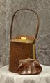 Bucket-style handbag of brown alligator leather with gold metal clasp closure at top