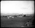 Buildings on campus, Oregon Agricultural College, Corvallis. Farm buildings and fields in foreground.