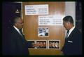 State Senator Walter Leth and Hal Schultz with economic statistics display for meat, poultry, and eggs, circa 1965