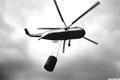 Ground to air view of an S-61 helicopter airborne with water bucket, Mitchell Creek Fire, Deschutes National Forest