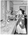 Women in vintage dress serving punch at a president's summer session reception; Memorial Union