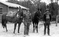 Two military staff with horses on beach patrol