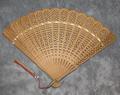 Folding fan of flat wooden sticks intricately carved with open-work shapes (simple figures)