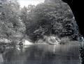 Lake or river, a dock, a man in a boat, and a woman sitting on the bank