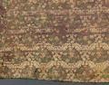 Textile fragment of brown silk satin brocaded in an all-over pattern of floral plants