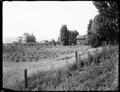 Garden and grounds of Samuel Hill home, Maryhill, Wa. House under construction in background. Orchards and vineyards in foreground.