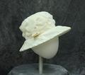 Hat of ivory organza folded and wrapped to create texture and design