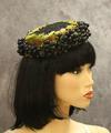 Pillbox hat of black woven fabric (maybe horsehair) encircled with green and rust ombre leaves and plastic "grapes"