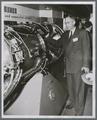A. L. Strand at machine show looking at GE airplane engine, 1951
