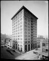 Wells Fargo building, 6th and Oak, Portland. Bank at street level. Wagons in street. Coca Cola Advertisement.