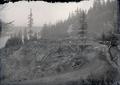 Road through logged hillside with river in background