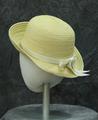 Hat of pale yellow and white striped straw with deep rounded crown
