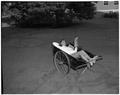 Promotional photo of an OSC co-ed reclining in a wheelbarrow and reading