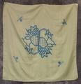 Textile square of sheer yellow nylon with large blue print of fruit basket at center