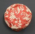 Pillbox cap of bright red silk with white embroidered vines, flowers and birds