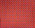 Textile yardage of bright red woven cotton with pattern of two alternating tiny squared floral motifs