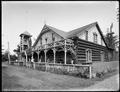 Driftwood Cottage, North Beach, WA., with guests sitting on porch of log building decorated with driftwood.