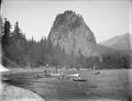 Castle Rock, on Washington shore of Columbia River. Sailboats and three rowboats in river, surrounding small steamboat, Sakana