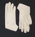 Gloves of off-white jersey knit accented with a string of bows embroidered along the top