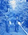 Two young men walking on a forest road