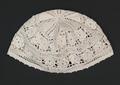 Skullcap of white needlework lace with floral bands and net pattern
