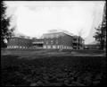 Large building at Multnomah County Poor Farm. Yard in foreground, power station in background.