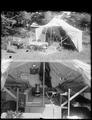 Copy of two photos on one negative: A) Collapsible tent-trailer assembled, with tables and stools in front of tent. B) Interior of tent, with beds, stoves, etc.