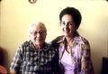 Mrs. Karaassos and Vasi Vlahakis in Mrs. Karassos' kitchen, with potholders