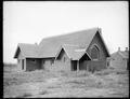 Grace Episcopal Church, Granger, WA., surrounded by weeds. Sapling trees in foreground.