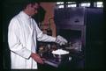 Food Science and Technology technician popping popcorn in electronic oven, Oregon State University, Corvallis, Oregon, circa 1965
