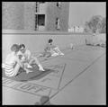 Students sunbathing and playing cards on the roof of Snell Hall