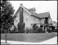William McMurray house, Portland, from front corner. Ivy-covered chimney on side of three-story wood house. Tree and sidewalk in foreground.