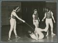 Three women pinning one to the ground in fencing class, 1938