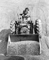 Woman driving front end loader loaded with gravel