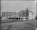 Failing School, Portland, with two girls on teeter-totter in school yard. Street in foreground.