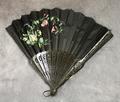 Folding fan of black wood carved with open-work circular floral designs
