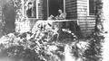 Walter Brown reading on porch at Walker Cottage