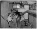 Barometer staff in heat tunnel to inspect new heating system, May 1952