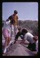 Person buried in sand at Camp Arago, Oregon, July 1969