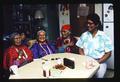 (Master Singer) Matilda Mitchell sits at table with her 2 sisters and apprentice Wilson Wewa (Washaat religious singing)