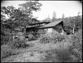 R. E. Scott home, Hood River, OR. Wood house on hill, surrounded by brush.