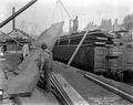 Spruce planks being loaded onto flatcars