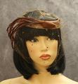 Halo or ring hat of woven brown straw covered with brown net veil