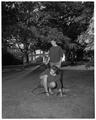 Promotional photo of two OSC co-eds watering grass with a garden hose