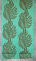 Textile Panel of turquoise green cotton with an over-sized print in brown of two vertical rows of a giant palm leaf