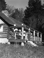 Peavy cabin with George Peavy standing on step